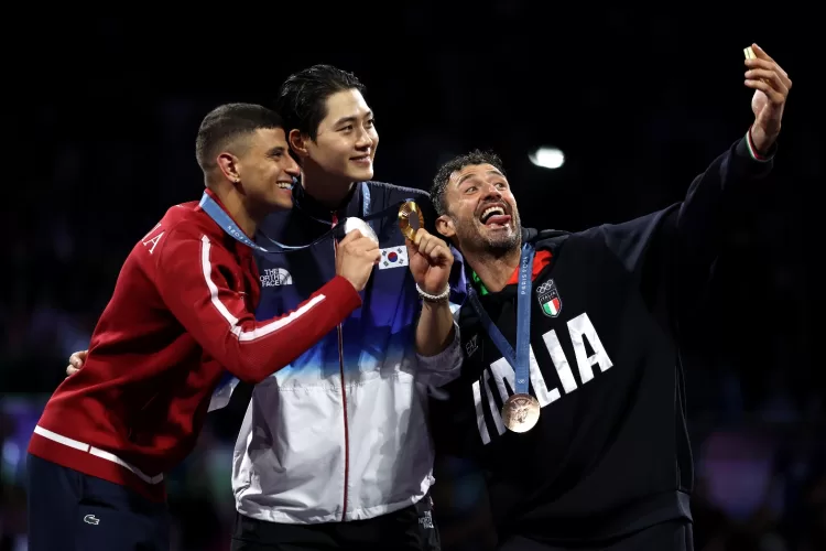 A group of men holding a medalDescription automatically generated