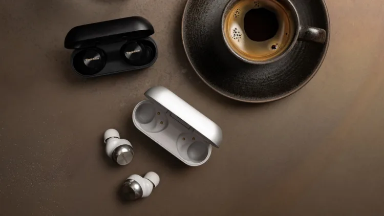 A cup of coffee and earbuds AI-generated content may be incorrect.