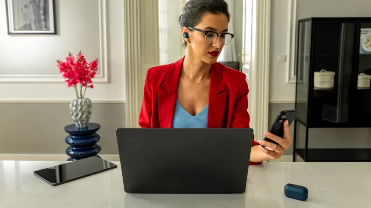 A person sitting at a desk with a computer and a phone AI-generated content may be incorrect.
